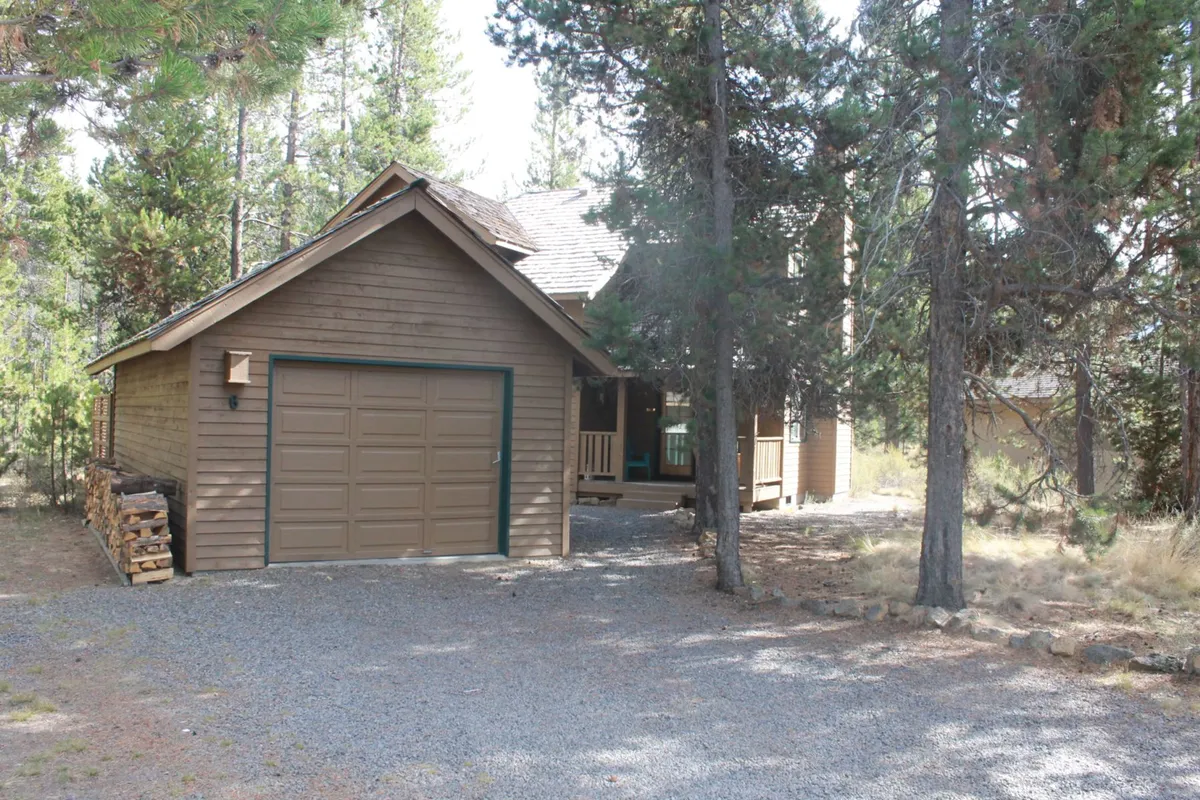 A peaceful view of the home’s wooden exterior, complete with a garage (where complimentary bikes might be stored), surrounded by mature trees. The setting feels private and calm, suggesting nights of stargazing and mornings enjoying coffee outdoors.